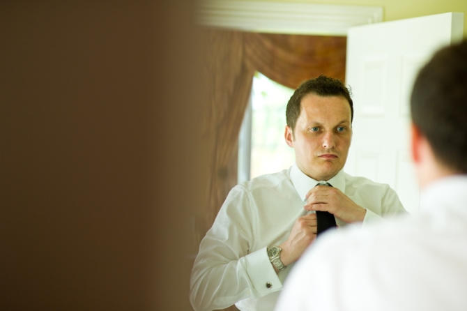 groom putting on tie